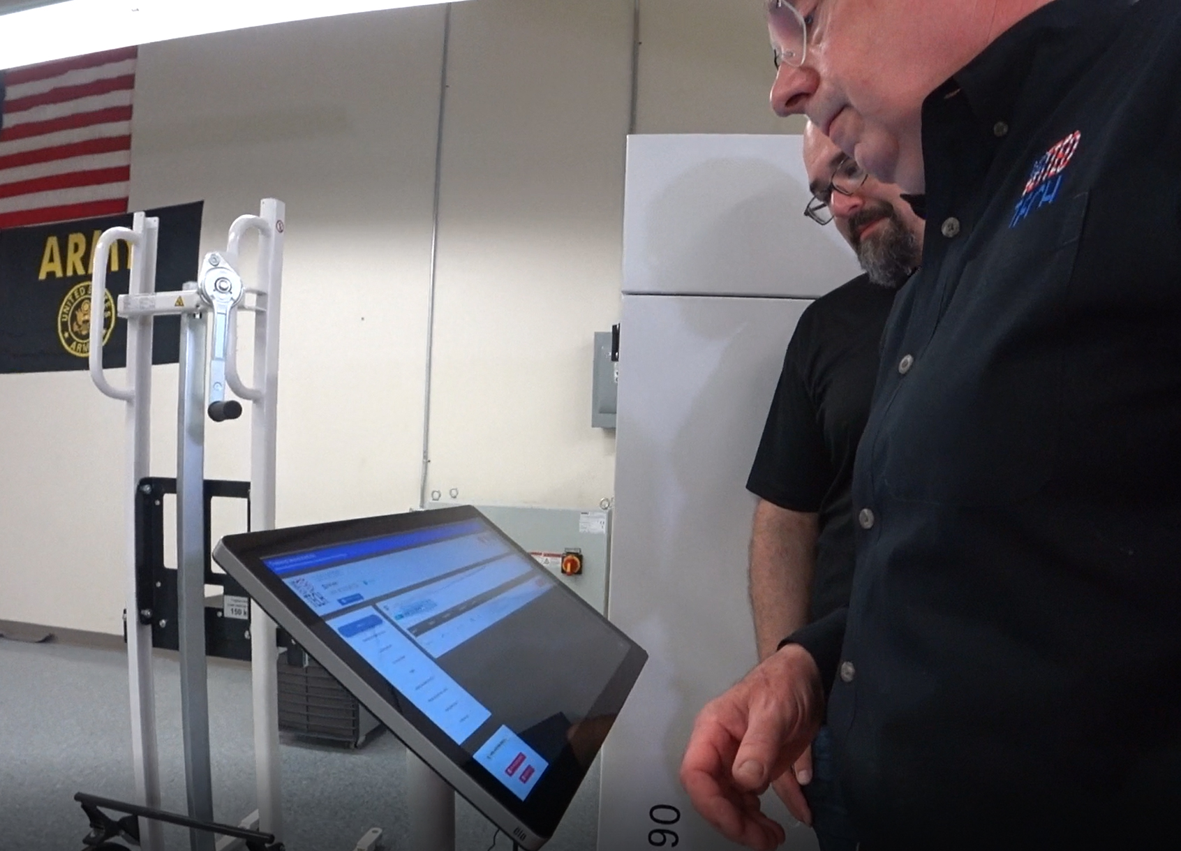 Two people looking at a MOLI touchscreen kiosk on a stand